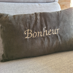 Coussin en velours vert foncé avec broderie Bonheur